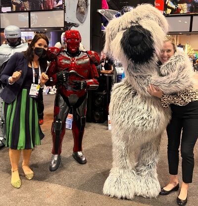 Two women hug actors in a transformer costume and a Wookie costume