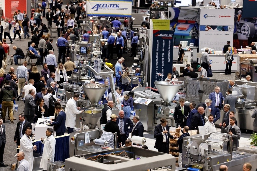 Busy trade show floor; crowds of people among booths