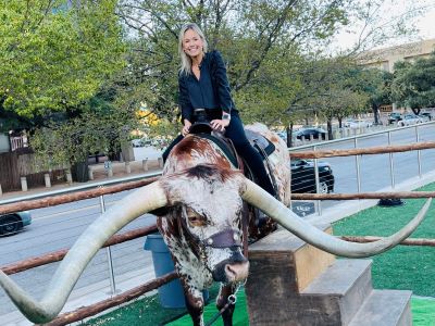 Woman sitting in saddle on Texas Longhorn bull